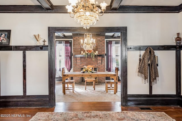 entryway with hardwood / wood-style flooring, beam ceiling, and a chandelier