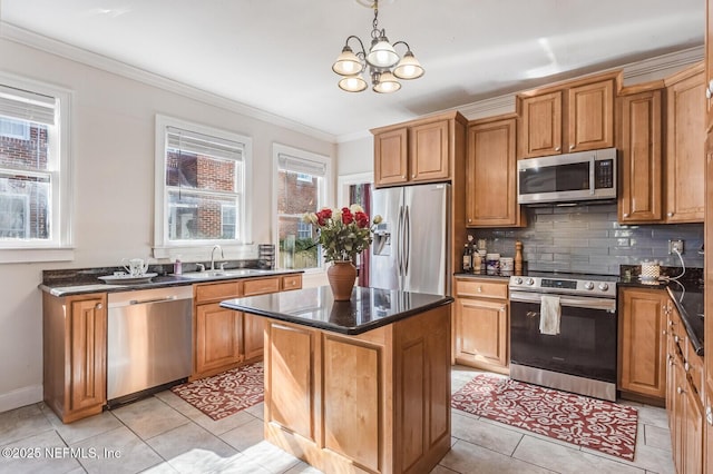 kitchen featuring hanging light fixtures, backsplash, stainless steel appliances, a center island, and ornamental molding