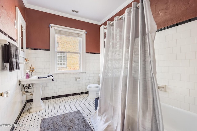 bathroom with shower / tub combo with curtain, ornamental molding, toilet, and tile walls