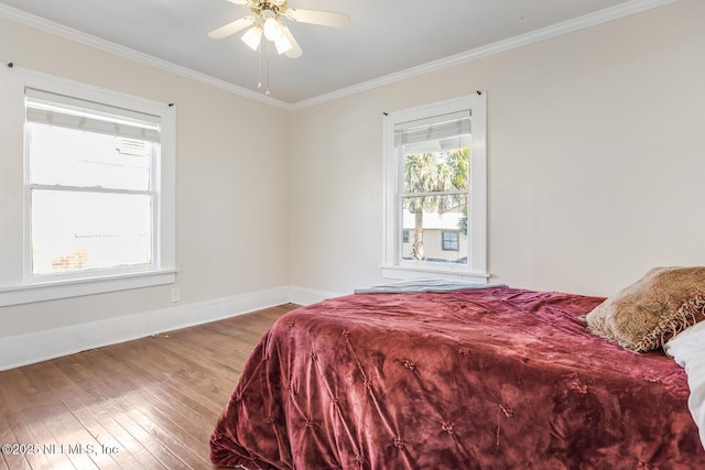 bedroom with hardwood / wood-style flooring, ornamental molding, and ceiling fan