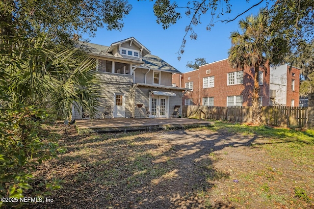 rear view of house with a sunroom, a deck, and a lawn