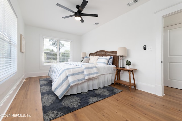 bedroom featuring baseboards, visible vents, and wood finished floors