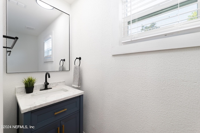 bathroom featuring a textured wall and vanity