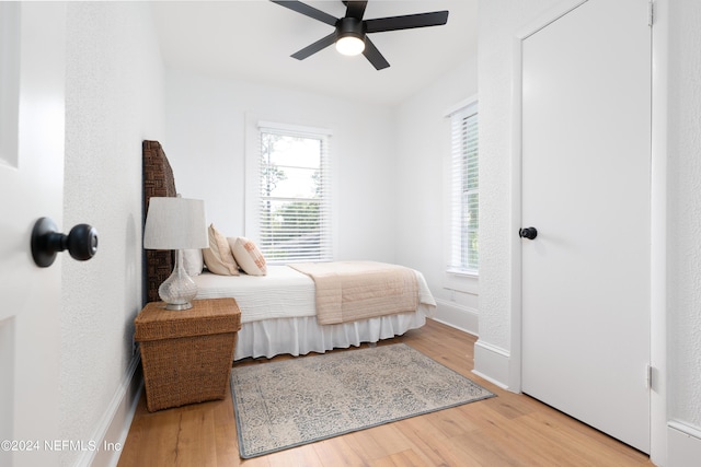 bedroom featuring ceiling fan, wood finished floors, and baseboards