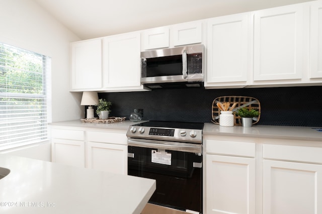 kitchen featuring backsplash, white cabinetry, stainless steel appliances, and light countertops