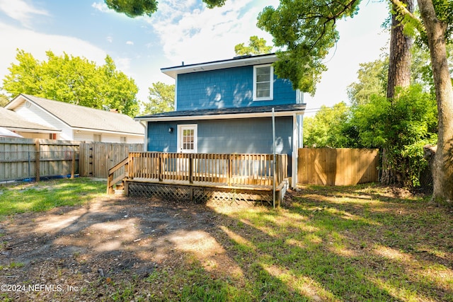 rear view of house with a fenced backyard and a wooden deck