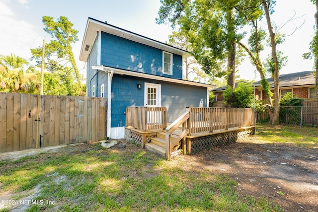 rear view of property featuring a fenced backyard and a deck