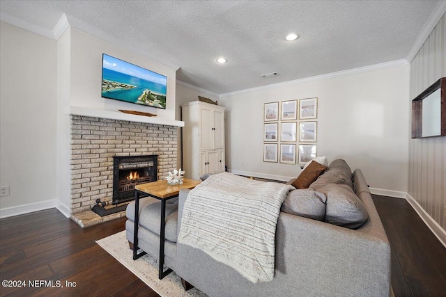 living room with dark hardwood / wood-style flooring, a textured ceiling, a brick fireplace, and ornamental molding