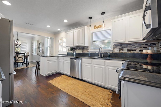 kitchen featuring white cabinets, sink, hanging light fixtures, and stainless steel appliances