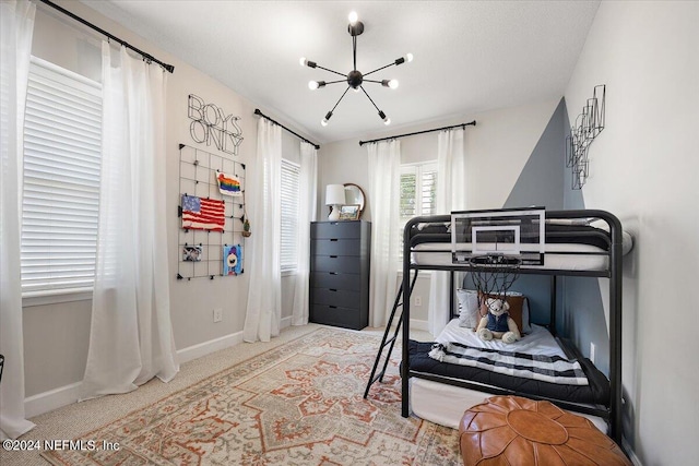 carpeted bedroom with a chandelier