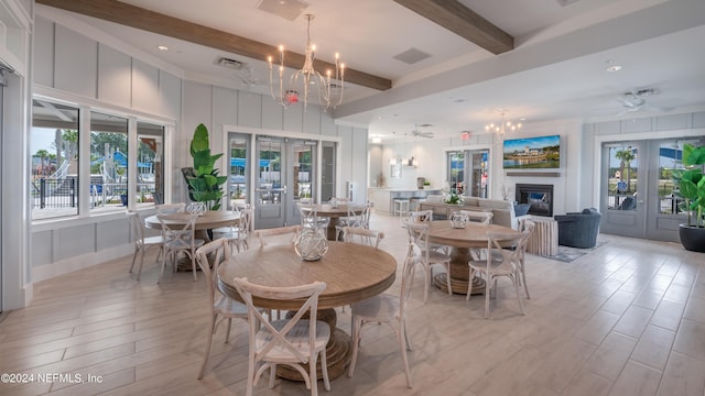 dining space with beamed ceiling, ceiling fan with notable chandelier, and french doors