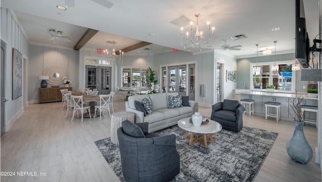 living room with ceiling fan with notable chandelier, french doors, beamed ceiling, and light wood-type flooring