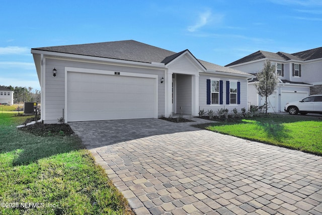 single story home with a garage, a front yard, and central air condition unit