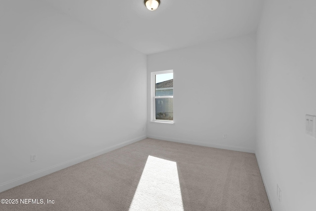 spare room featuring light colored carpet