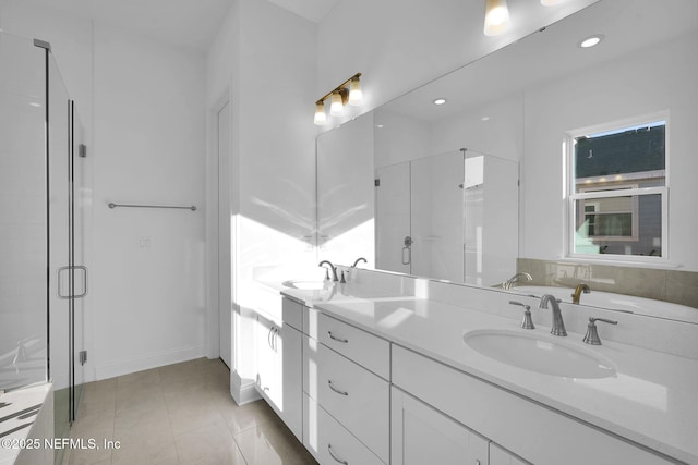 bathroom with a shower with shower door and vanity