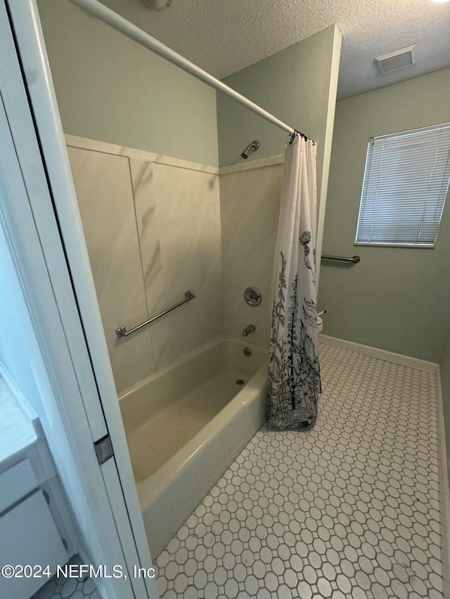 bathroom featuring shower / bath combination with curtain, a textured ceiling, and tile patterned floors