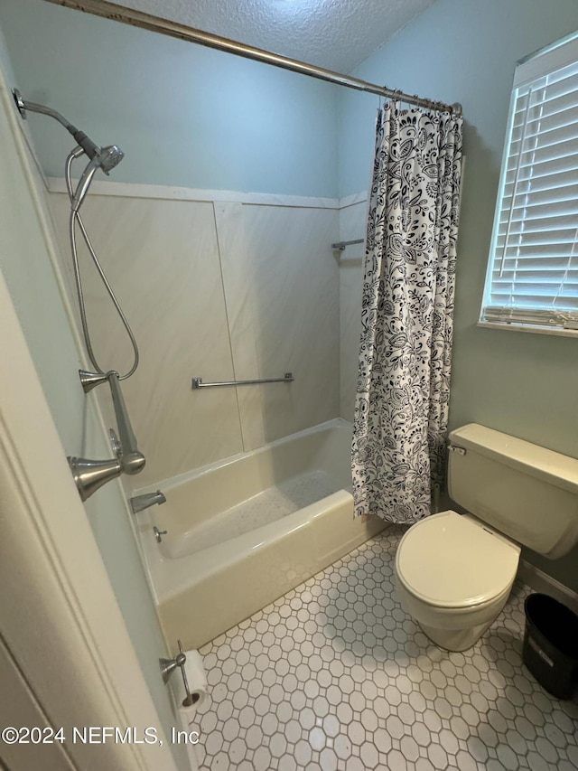 bathroom featuring tile patterned floors, shower / bath combination with curtain, a textured ceiling, and toilet