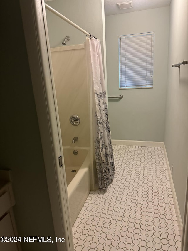 bathroom featuring tile patterned floors and shower / bath combo with shower curtain