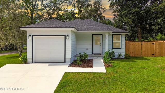 ranch-style house with a garage and a yard