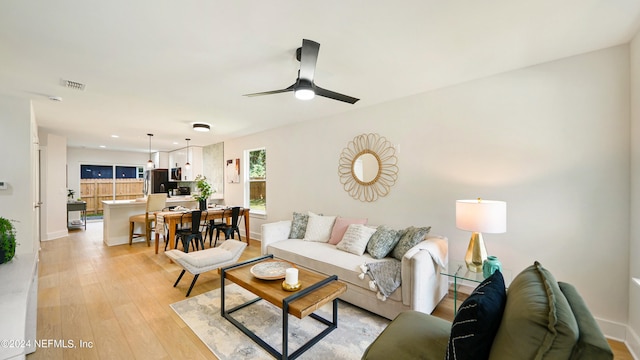 living room with light wood-type flooring and ceiling fan