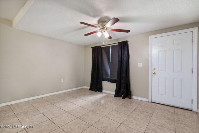 tiled spare room featuring ceiling fan and a textured ceiling