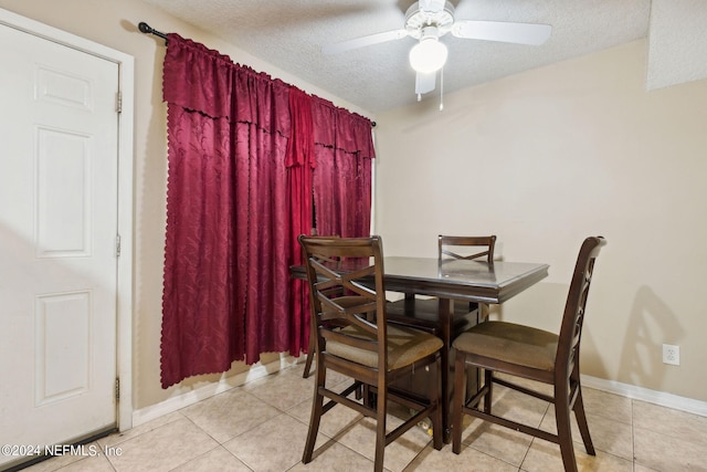 dining room with ceiling fan, light tile patterned flooring, and a textured ceiling