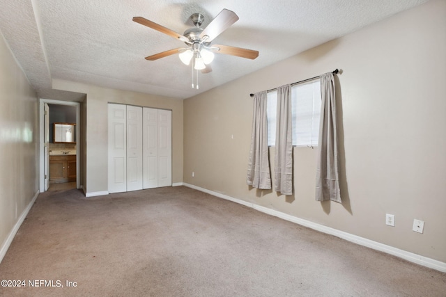 unfurnished bedroom featuring carpet floors, a textured ceiling, ceiling fan, and a closet