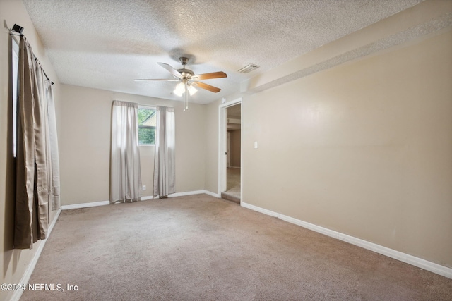 carpeted empty room featuring a textured ceiling and ceiling fan