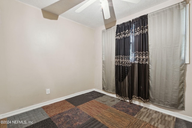 carpeted empty room with a textured ceiling and ceiling fan