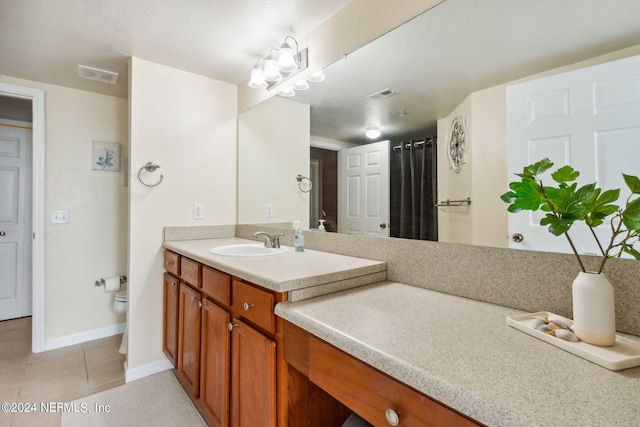 bathroom featuring tile patterned flooring, vanity, and toilet