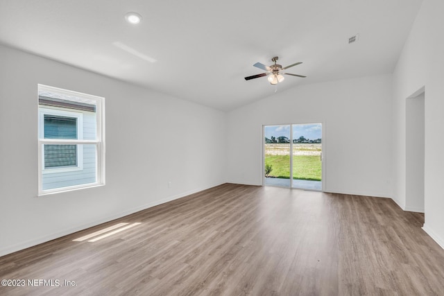 spare room featuring light hardwood / wood-style floors, vaulted ceiling, and ceiling fan