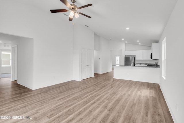 unfurnished living room featuring light hardwood / wood-style flooring, high vaulted ceiling, and ceiling fan