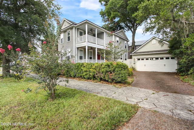 view of front of home with a garage, a balcony, and a front yard