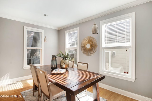 dining space featuring crown molding and light hardwood / wood-style floors