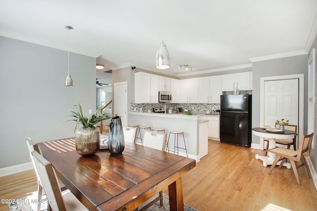 dining room featuring crown molding, ceiling fan, and light hardwood / wood-style flooring