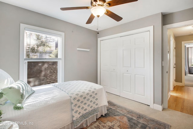 carpeted bedroom featuring a closet and ceiling fan