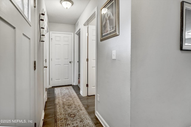 hallway featuring dark hardwood / wood-style flooring and a textured ceiling