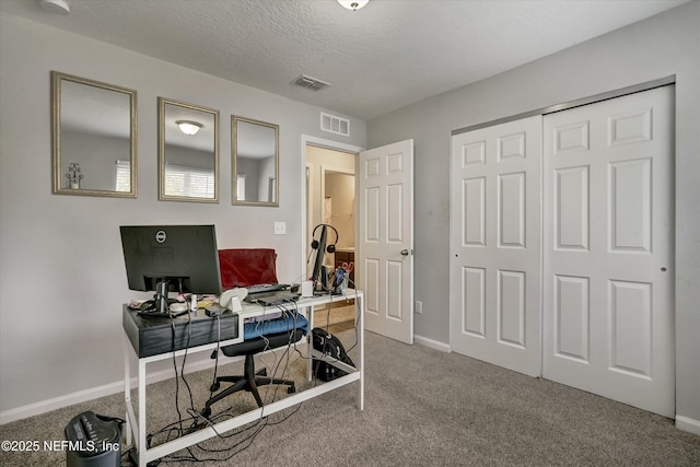 carpeted office featuring a textured ceiling