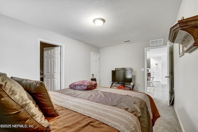 bedroom featuring carpet flooring and a textured ceiling