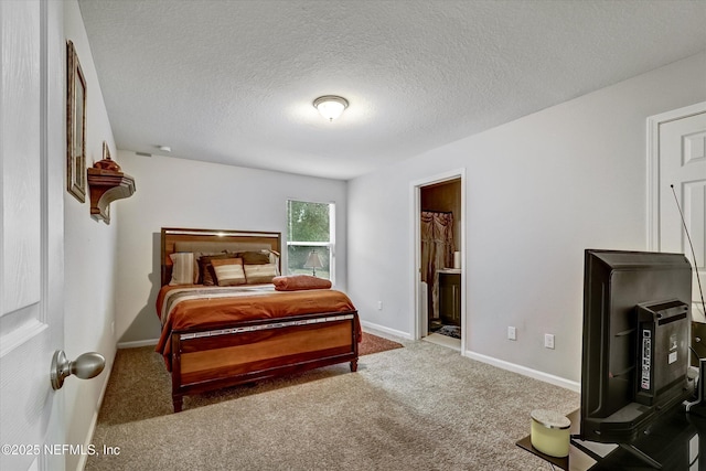 bedroom featuring carpet flooring, ensuite bath, a spacious closet, and a textured ceiling