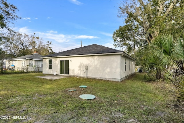 rear view of property featuring a yard and a patio