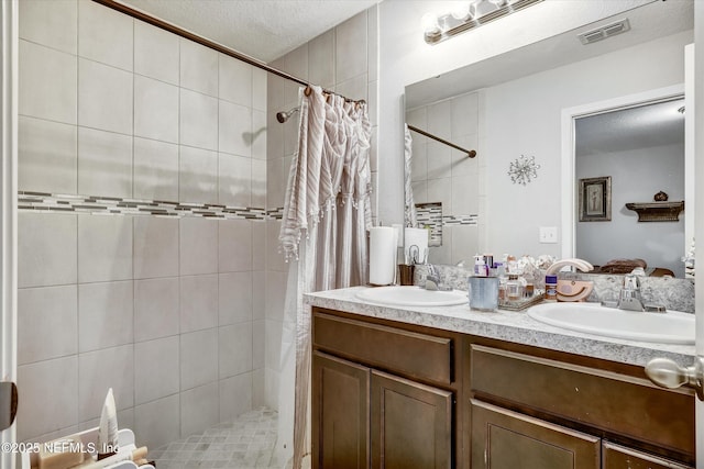 bathroom with a shower with shower curtain, a textured ceiling, and vanity