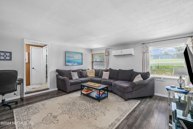 living room with a wall mounted air conditioner, dark wood-type flooring, and a textured ceiling