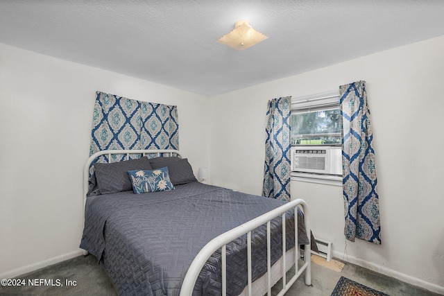 bedroom with a baseboard heating unit, cooling unit, a textured ceiling, and carpet flooring