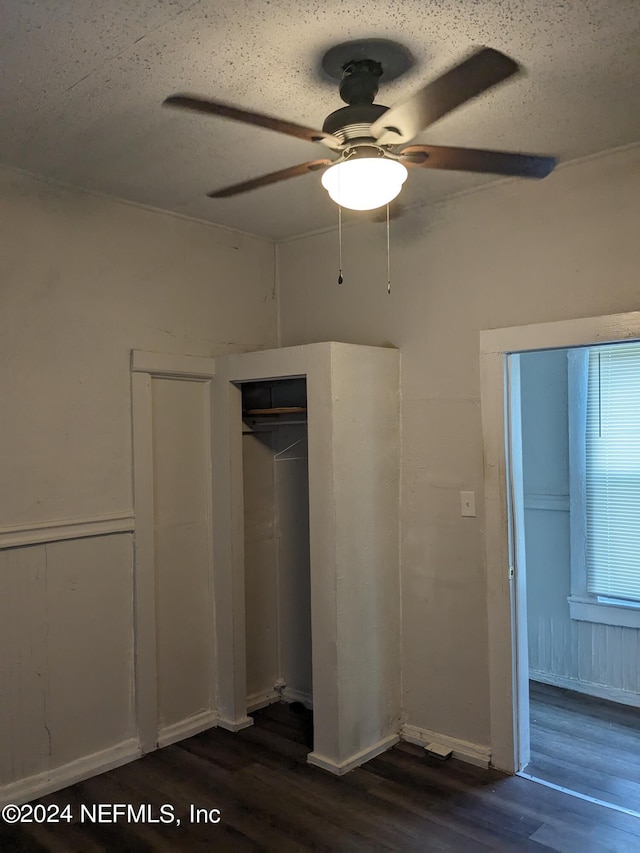 unfurnished bedroom with a textured ceiling, dark hardwood / wood-style floors, and ceiling fan