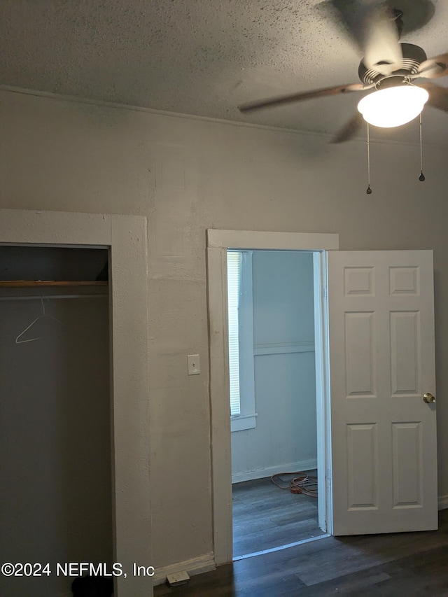 unfurnished bedroom featuring ceiling fan and dark wood-type flooring