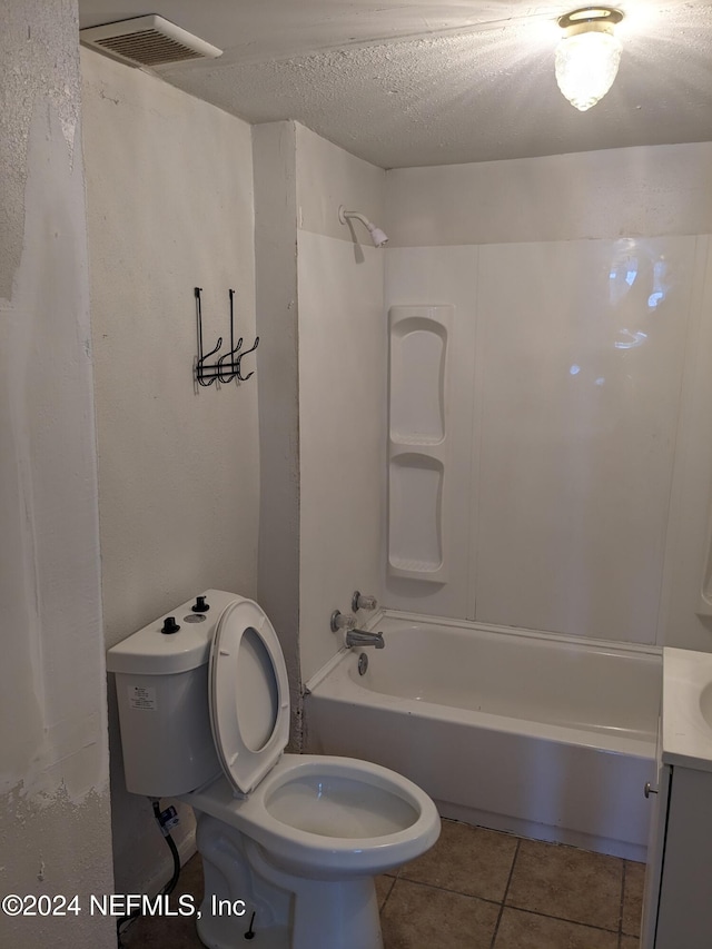 full bathroom featuring vanity, tile patterned flooring, toilet, a textured ceiling, and shower / bathtub combination