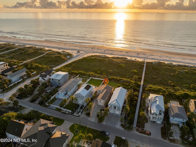 aerial view at dusk featuring a residential view and a water view