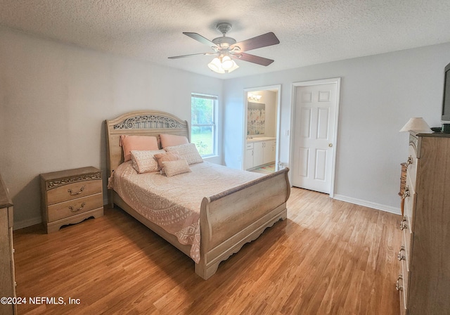 bedroom featuring ceiling fan, ensuite bath, a textured ceiling, and light hardwood / wood-style flooring