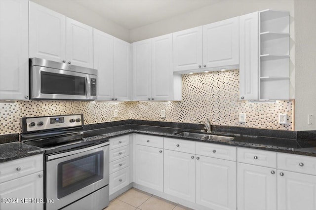 kitchen with decorative backsplash, stainless steel appliances, white cabinetry, and sink